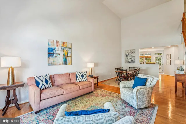 a kitchen with stainless steel appliances granite countertop a stove a sink a microwave a refrigerator and white cabinets with wooden floor