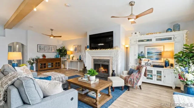 a living room with furniture a flat screen tv and a fireplace