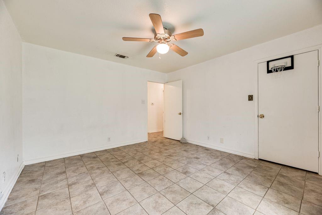 298 Butterfield Road Denison, TX 75021 - Photo 14 of 34 Spacious interior room featuring tile flooring, white walls, and a ceiling fan with light fixture