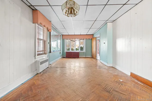 a big room with chandelier fan and windows