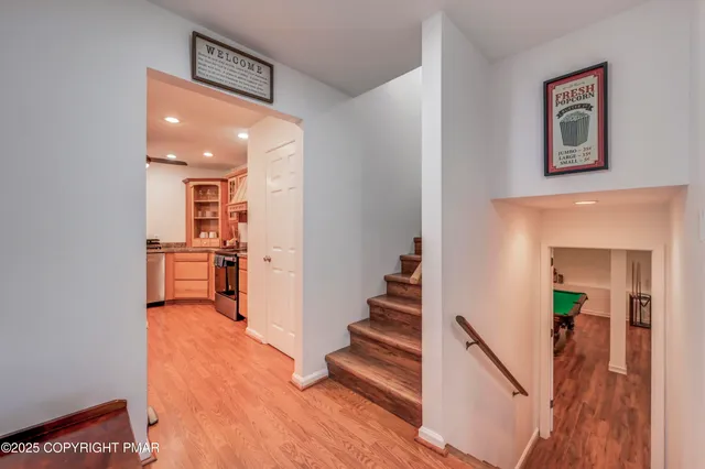 a view of a hallway with wooden floor and staircase