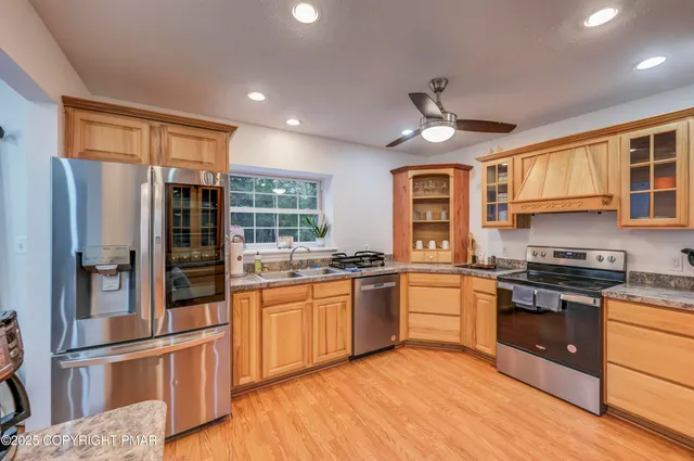 a kitchen with stainless steel appliances granite countertop hardwood floor sink stove and refrigerator