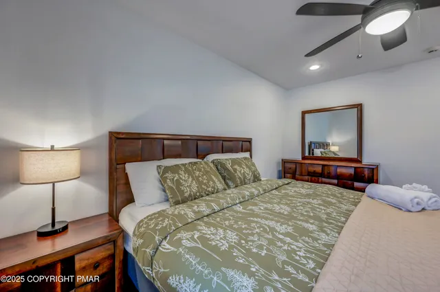 a bedroom with a large bed and a chandelier