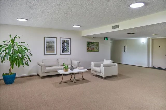 a view of a kitchen with kitchen island a sink wooden floor and a refrigerator