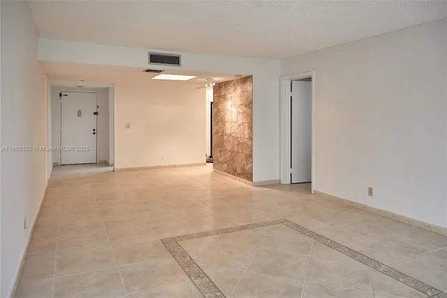 a view of a kitchen with stainless steel appliances a large counter top and stove top oven with wooden floor