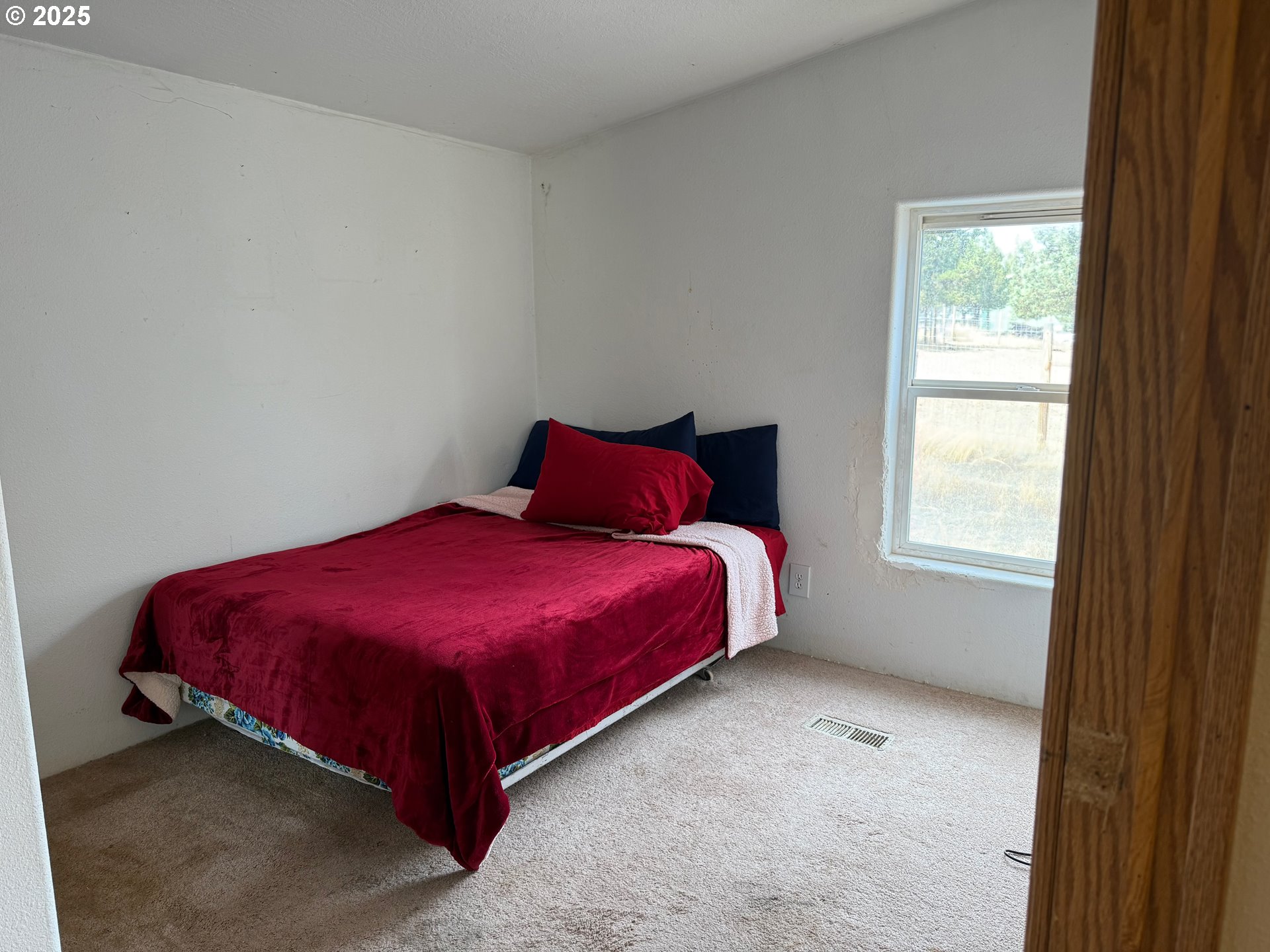 9071 Southwest Sand Ridge Road Terrebonne, OR 97760 - Photo 25 of 40 a spacious bedroom with a bed and window