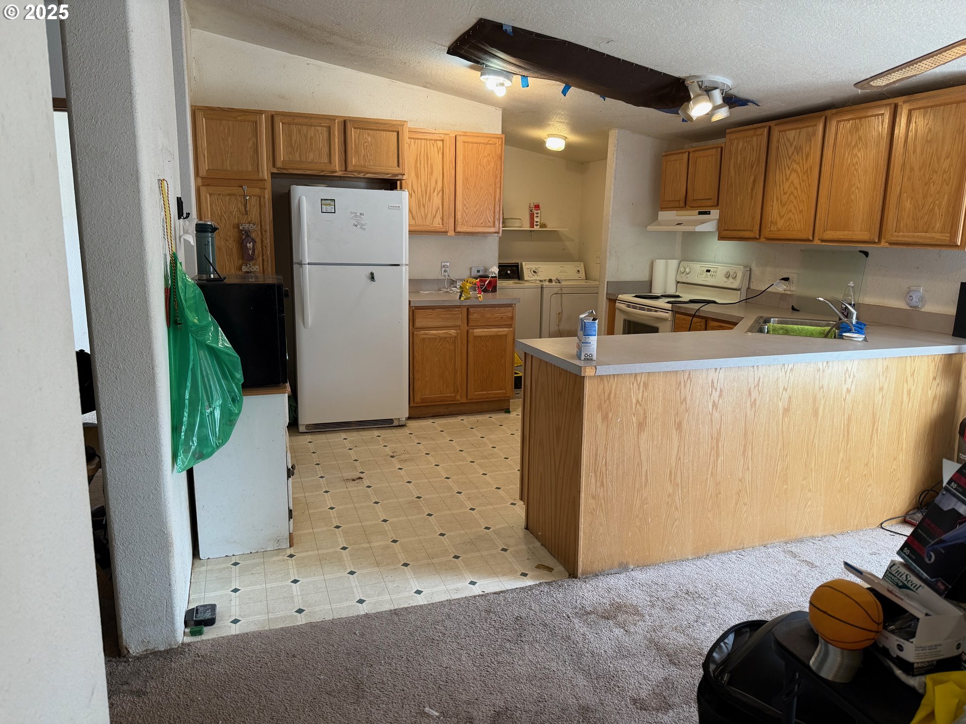 9071 Southwest Sand Ridge Road Terrebonne, OR 97760 - Photo 9 of 40 a kitchen with a refrigerator a stove top oven a sink and cabinets
