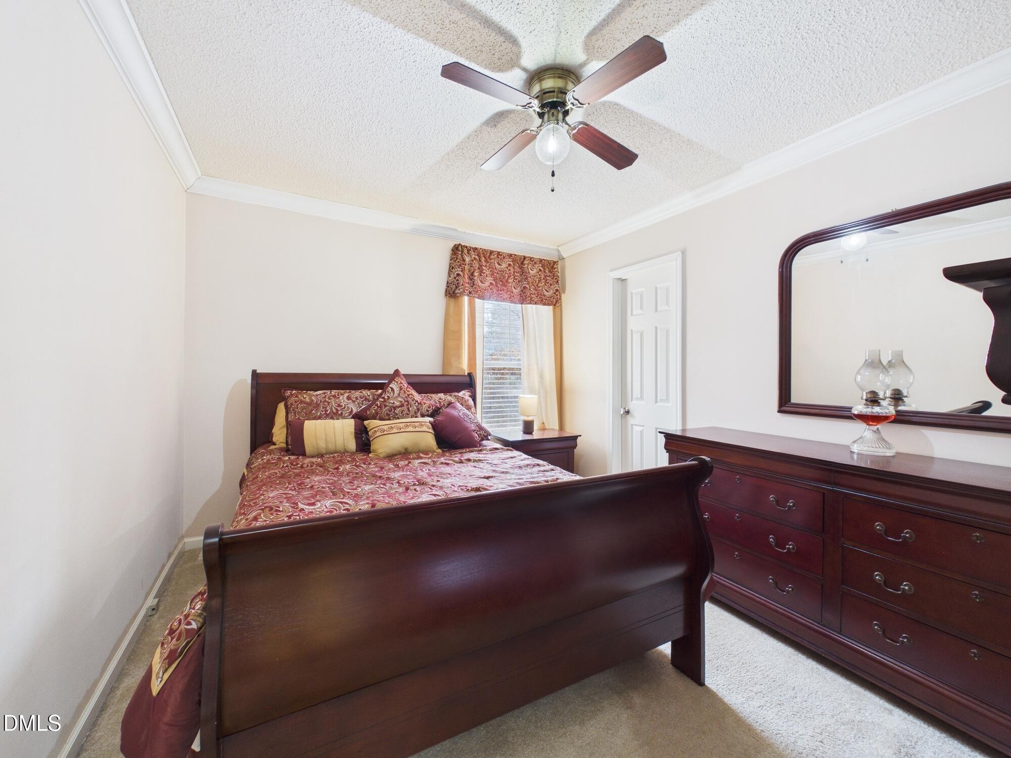2528 Dalton Mill Road Bullock, NC 27507 - Photo 14 of 21 a bedroom with a large bed and a chandelier