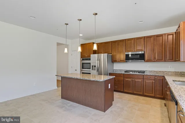 a kitchen with stainless steel appliances granite countertop a sink a stove and a refrigerator