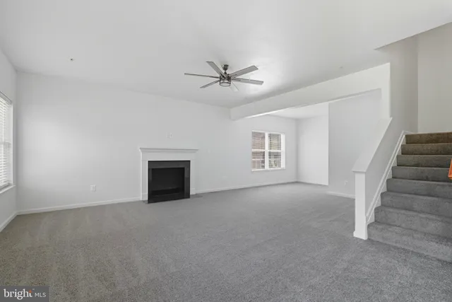 an empty room with a ceiling fan and windows