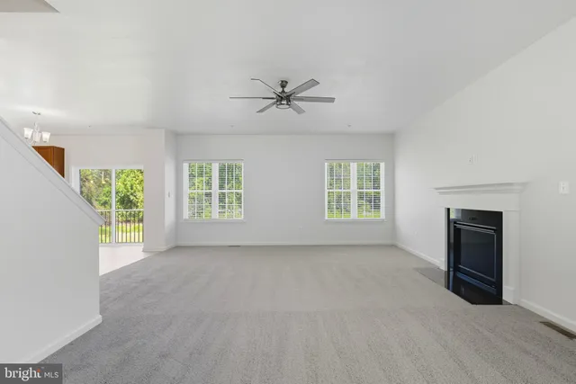 an empty room with windows and ceiling fan
