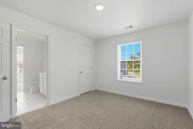 an empty room with a bathroom and a sink