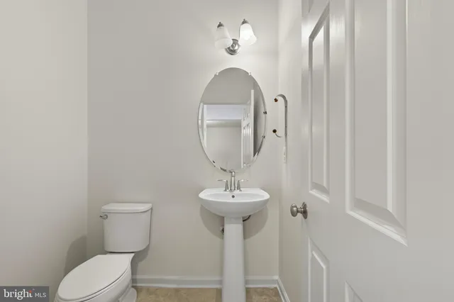 a bathroom with a toilet sink and a mirror