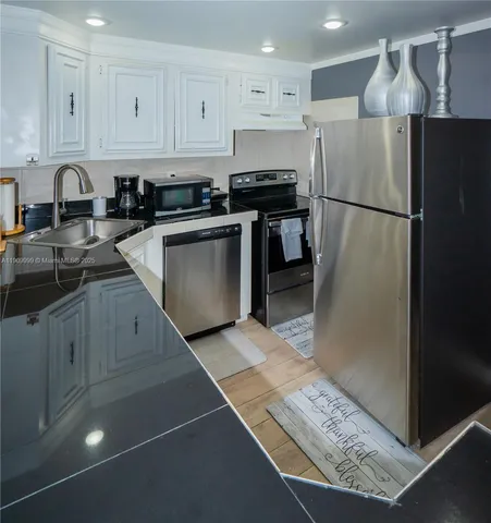 a kitchen with a refrigerator sink and cabinets