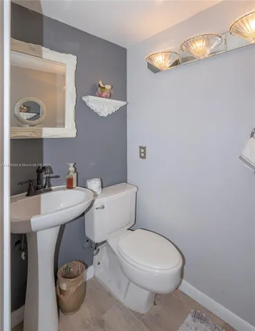 a bathroom with a toilet a sink and mirror