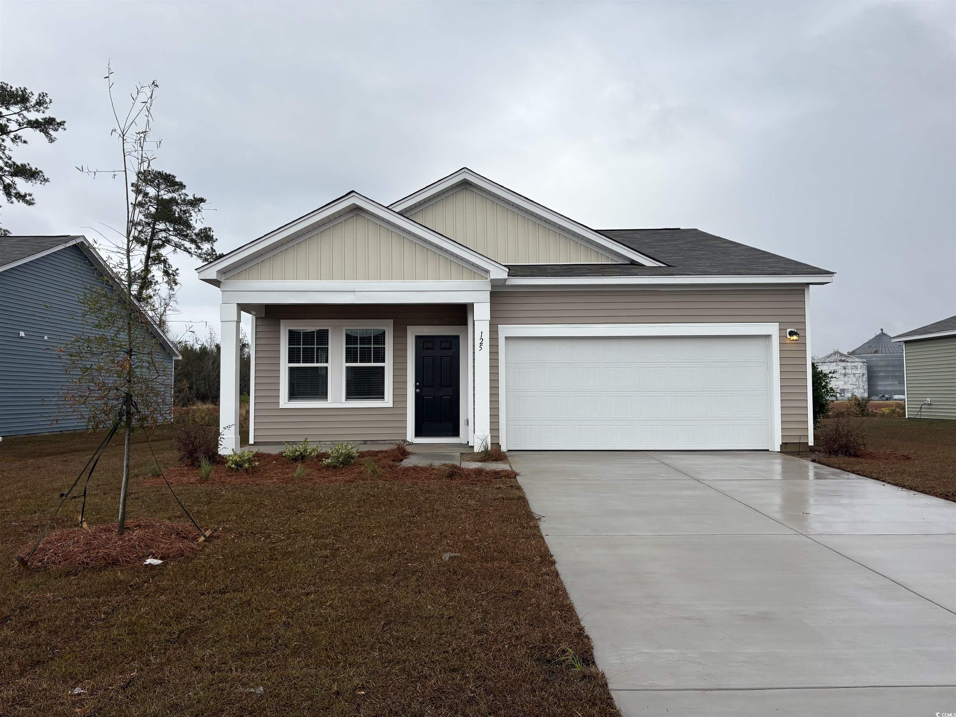 View of front of home with driveway, board and batten siding, an attached garage, and a shingled roof