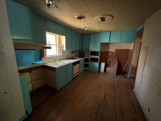 a kitchen with a refrigerator a sink dishwasher stove and wooden cabinets