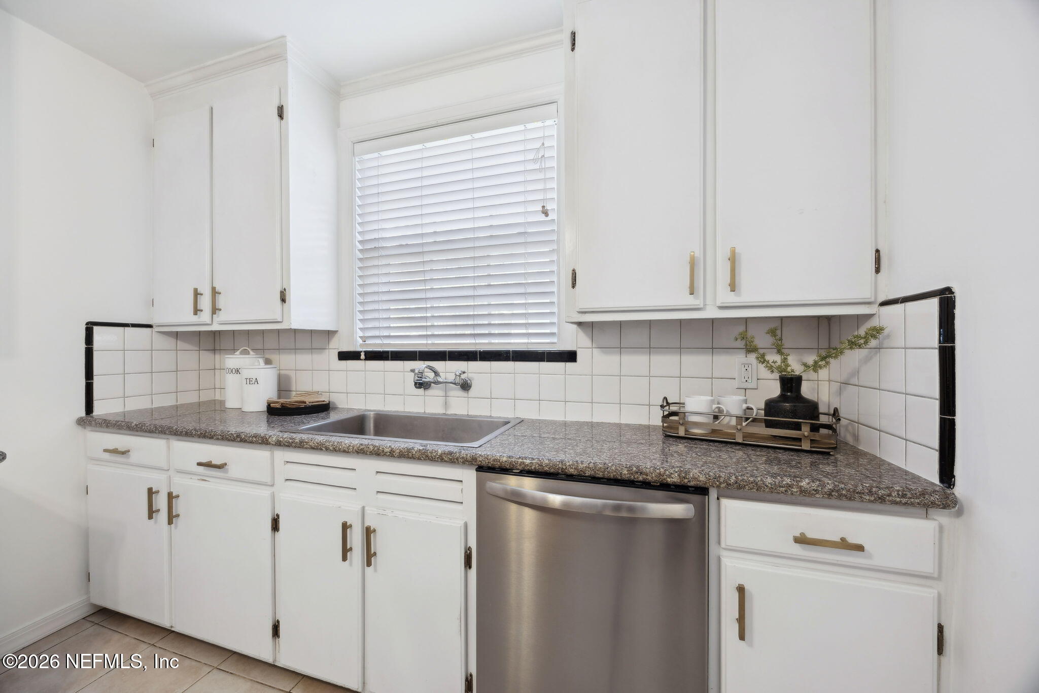 1626 Brookwood Road Jacksonville, FL 32207 - Photo 16 of 98 a kitchen with granite countertop white cabinets and white appliances