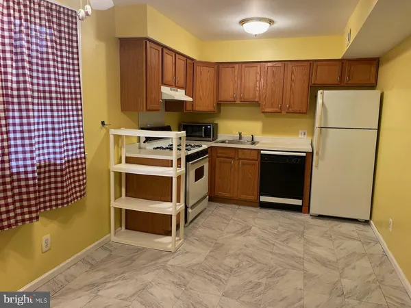 a kitchen with a refrigerator sink and cabinets