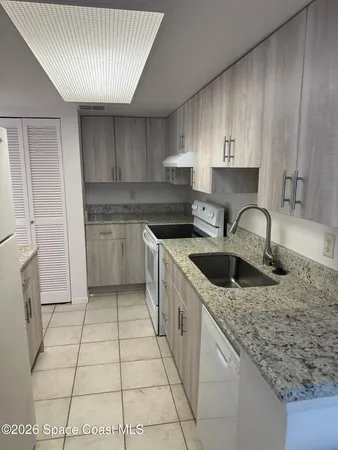 a kitchen with a sink a stove and cabinets