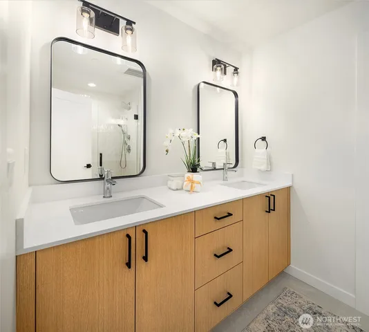 a bathroom with double vanity sinks and a mirror