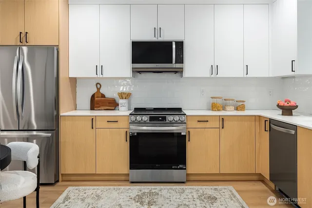 a kitchen with stainless steel appliances granite countertop a refrigerator stove and white cabinets