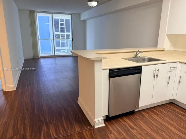 a view of a kitchen with wooden floor and a sink