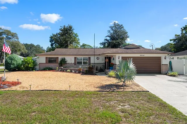 a front view of house with yard and trees around