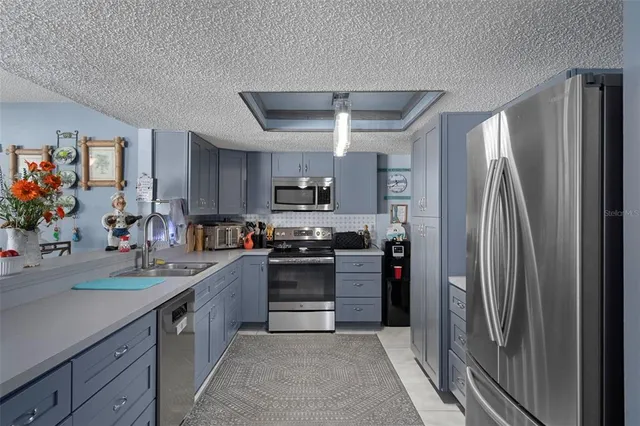 a kitchen with stainless steel appliances granite countertop a refrigerator and a sink