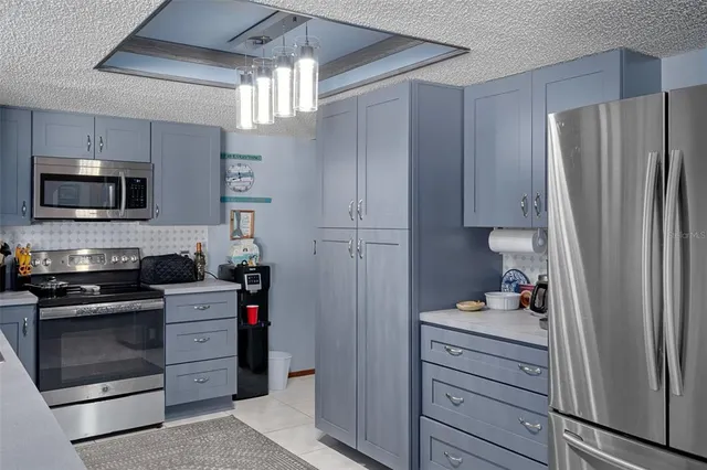 a kitchen with stainless steel appliances a refrigerator and a dining table