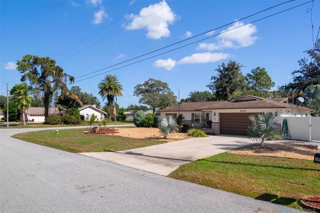 a view of a house with backyard and a tree