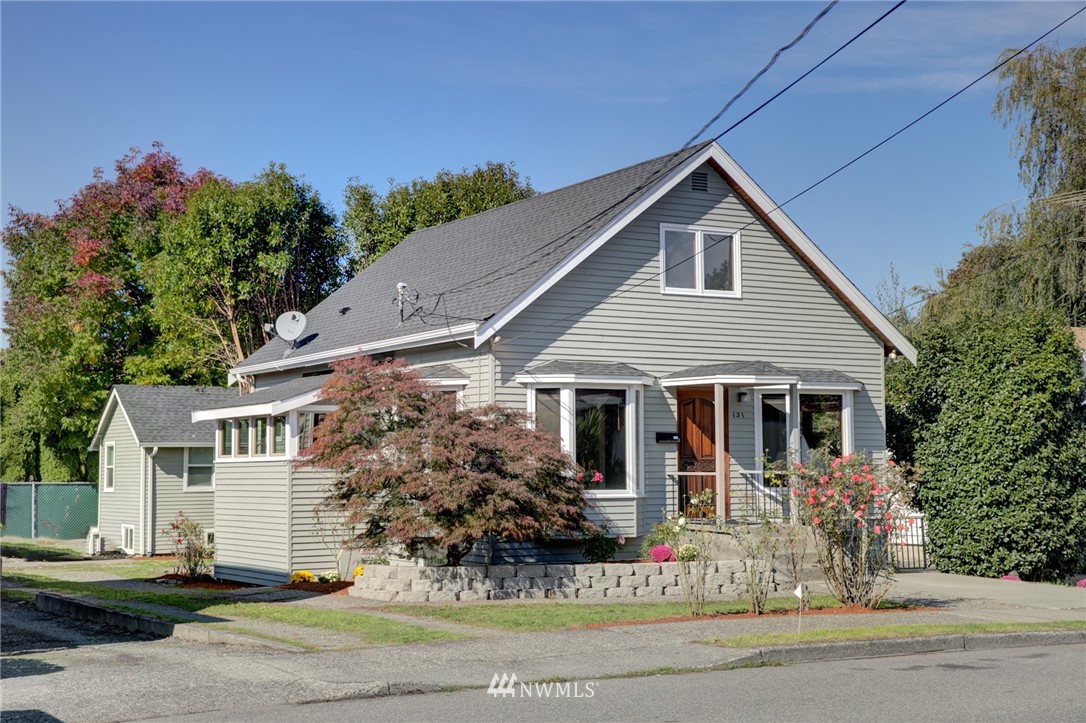 a front view of house with yard and trees in the background