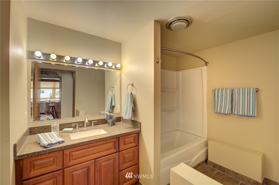 121 Logan Avenue South Renton, WA 98057 - Photo 11 of 25 a bathroom with a double vanity sink a mirror and a shower