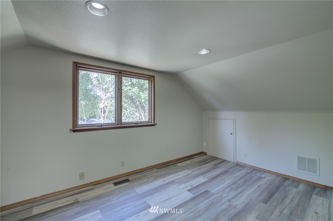 121 Logan Avenue South Renton, WA 98057 - Photo 13 of 25 an empty room with wooden floor and windows