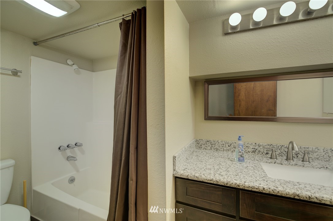 121 Logan Avenue South Renton, WA 98057 - Photo 18 of 25 a bathroom with a granite countertop sink and a mirror