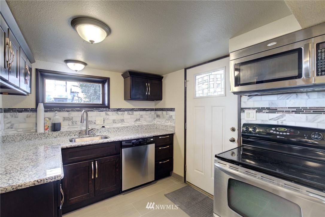 121 Logan Avenue South Renton, WA 98057 - Photo 19 of 25 a kitchen with stainless steel appliances a stove sink and microwave