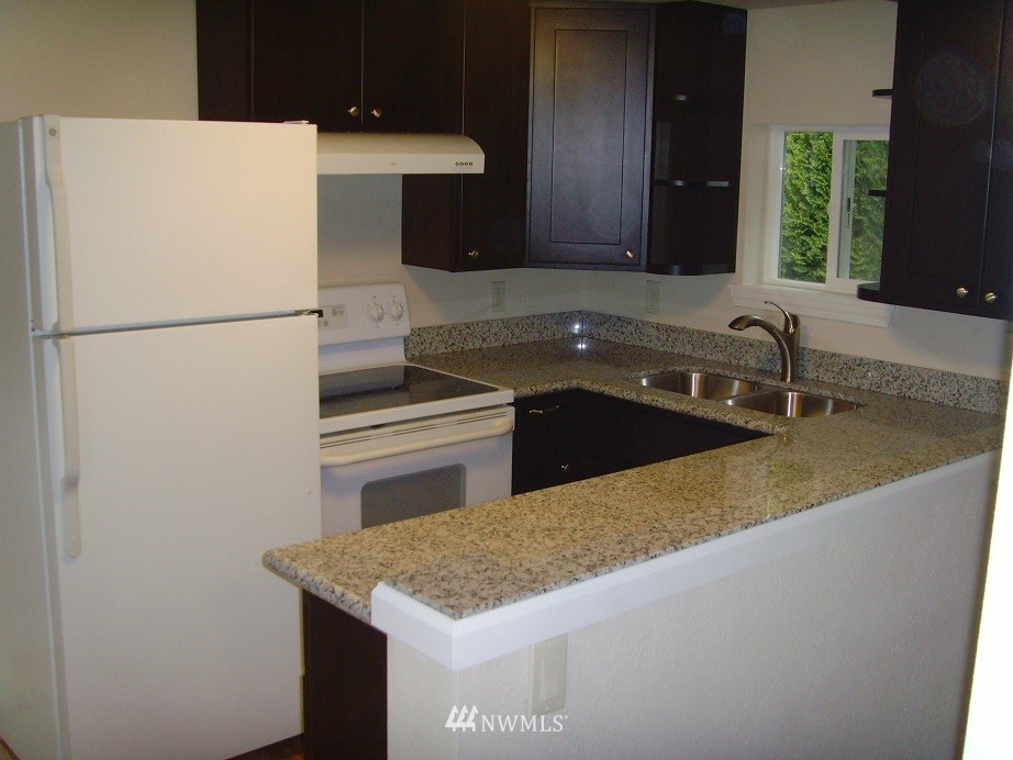 121 Logan Avenue South Renton, WA 98057 - Photo 22 of 25 a kitchen with a sink a stove and a refrigerator