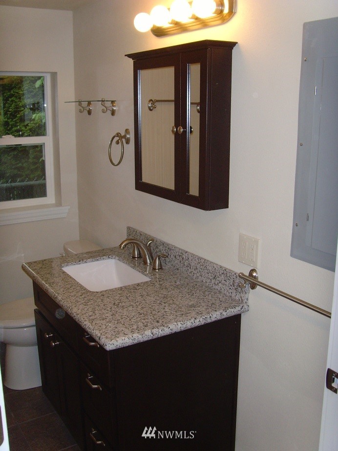 121 Logan Avenue South Renton, WA 98057 - Photo 25 of 25 a bathroom with a granite countertop sink and a mirror