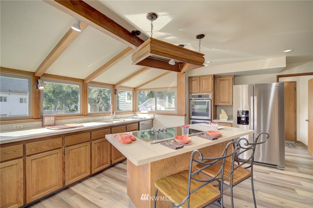 121 Logan Avenue South Renton, WA 98057 - Photo 7 of 25 a dining hall with stainless steel appliances kitchen island granite countertop a sink and cabinets