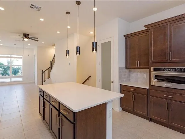 a kitchen that has a lot of cabinets in it and wooden floors