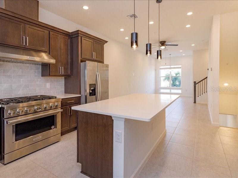2353 Brix Street Orlando, FL 32804 - Photo 12 of 25 a kitchen with kitchen island a stove a sink a refrigerator and trees