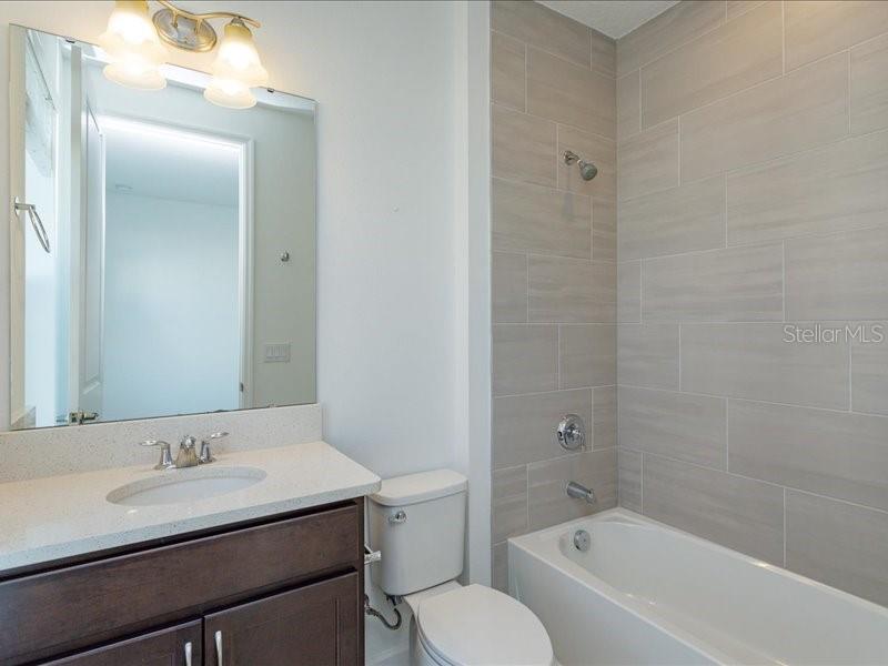 2353 Brix Street Orlando, FL 32804 - Photo 16 of 25 a bathroom with a granite countertop sink toilet a mirror and shower