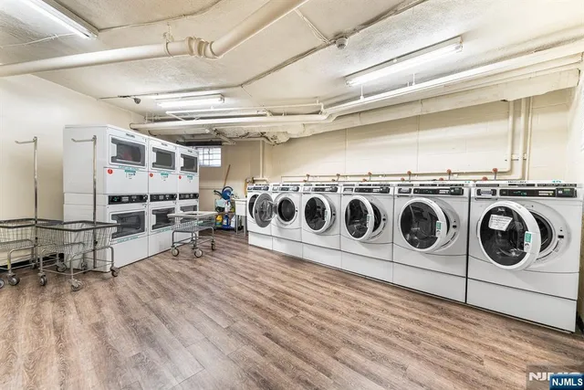 a utility room with stainless steel appliances and wooden floors