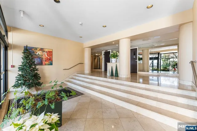 a living room with a large window and potted plants