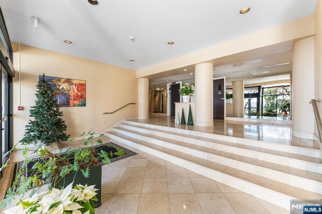 1375 River Road, Unit 1K Edgewater, NJ 07020 - Photo 6 of 27 a living room with a large window and potted plants