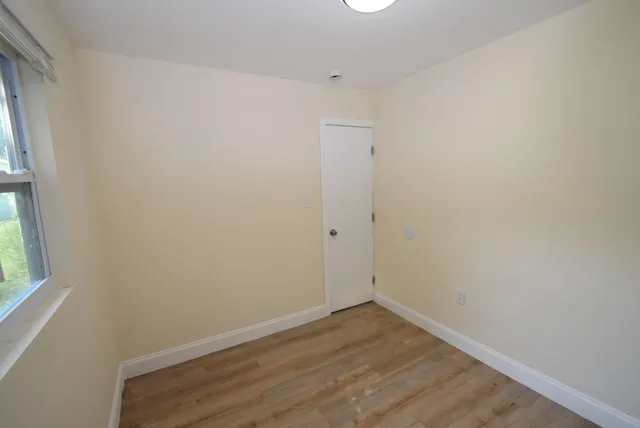 a view of small space with wooden floor and window