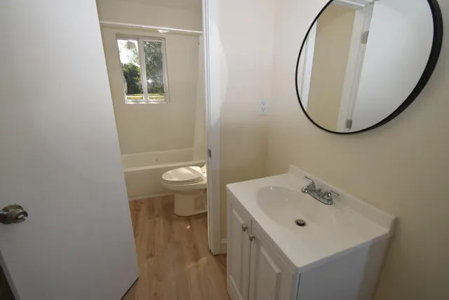 a bathroom with a sink a toilet and a mirror