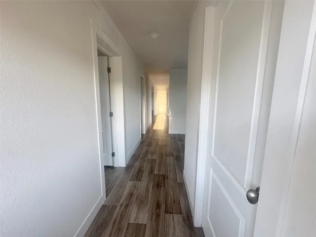 a view of a hallway with wooden floor
