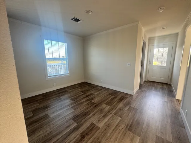 a view of a room with wooden floor and window