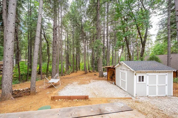 a view of a house with backyard and trees